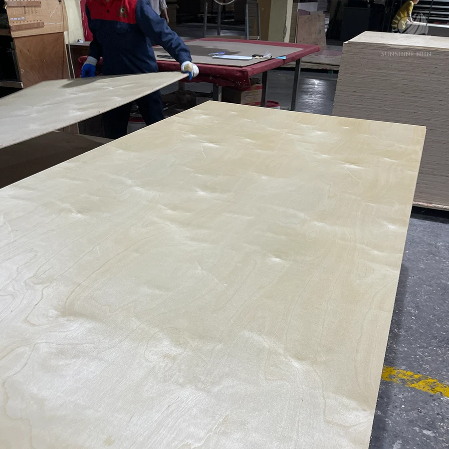 Factory workers handling a large premium veneer plywood panel at SunShine NHN facility.